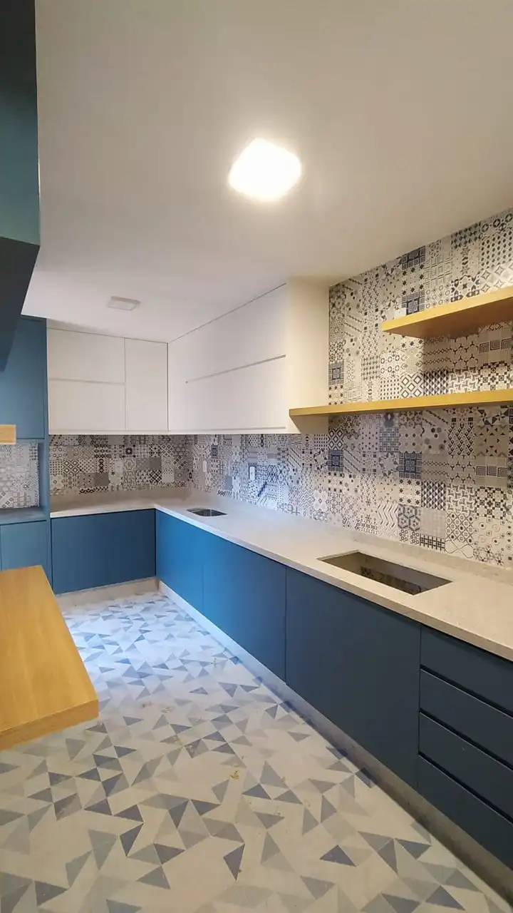 Cozinha planejada em azul petróleo com prateleiras em madeira e bancada clara