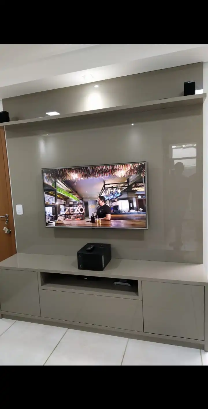 Painel de TV em laca com rack embutido e iluminação superior na sala