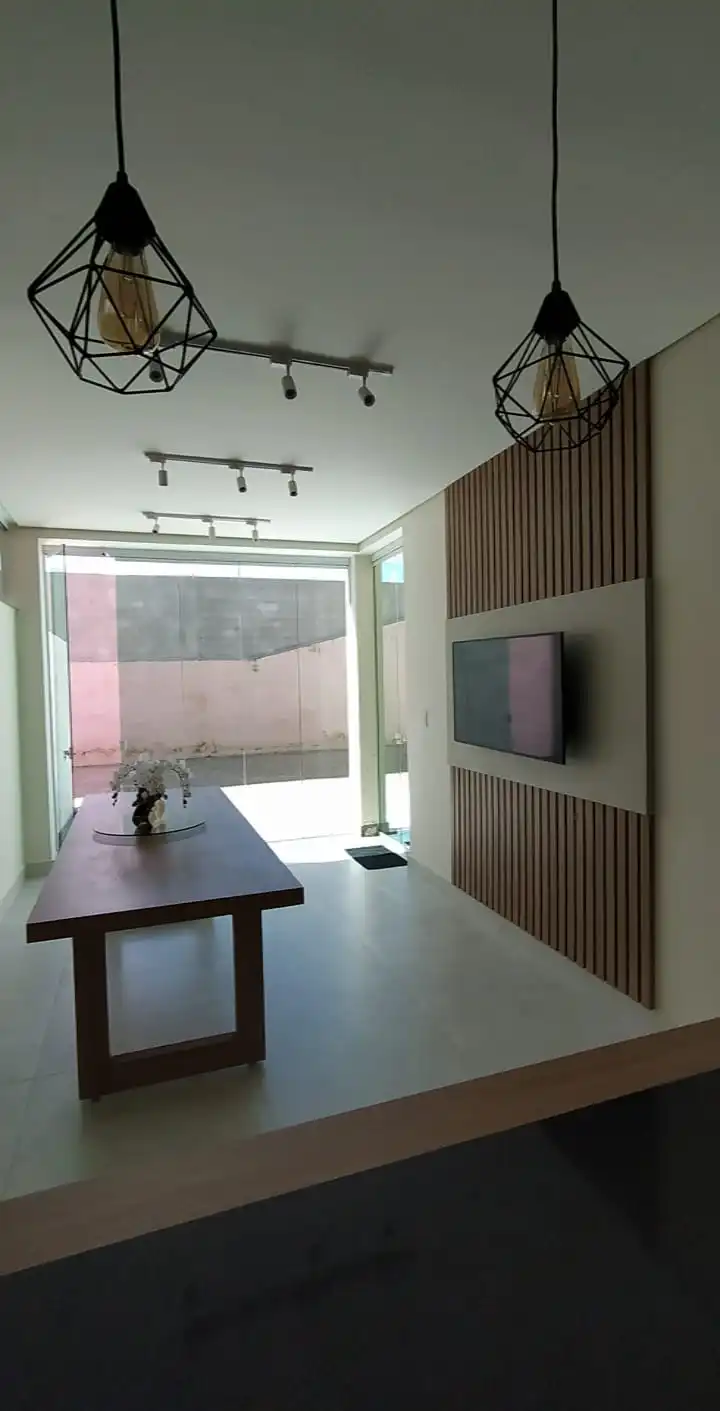 Sala comercial com painel ripado de madeira, mesa de reunião e iluminação em trilho